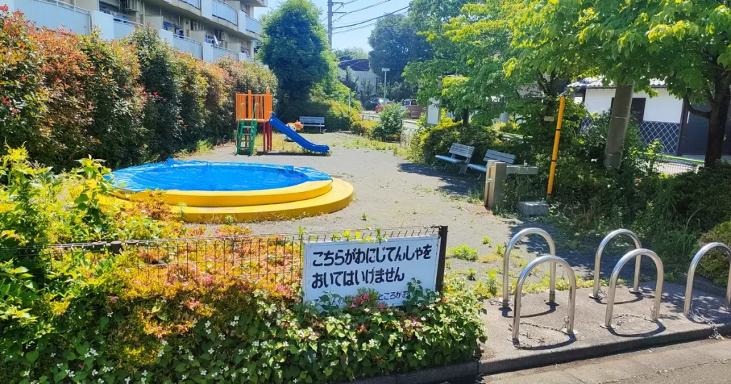 青葉台東公園の砂場とすべり台、動物モチーフの乗り物遊具が並ぶ遊び場の風景