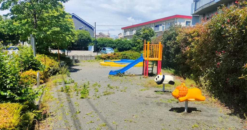 青葉台東公園の砂場とすべり台、動物モチーフの乗り物遊具が並ぶ遊び場の風景